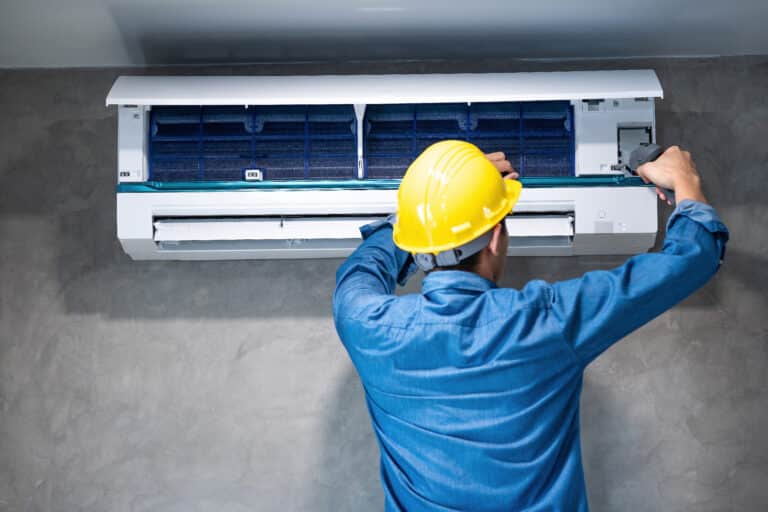 Technicien entretenant un climatiseur, y compris l'unité extérieure