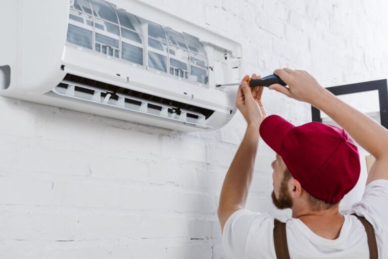 Technicien Lille Chauffage changeant le filtre d'un climatiseur lors d'un entretien